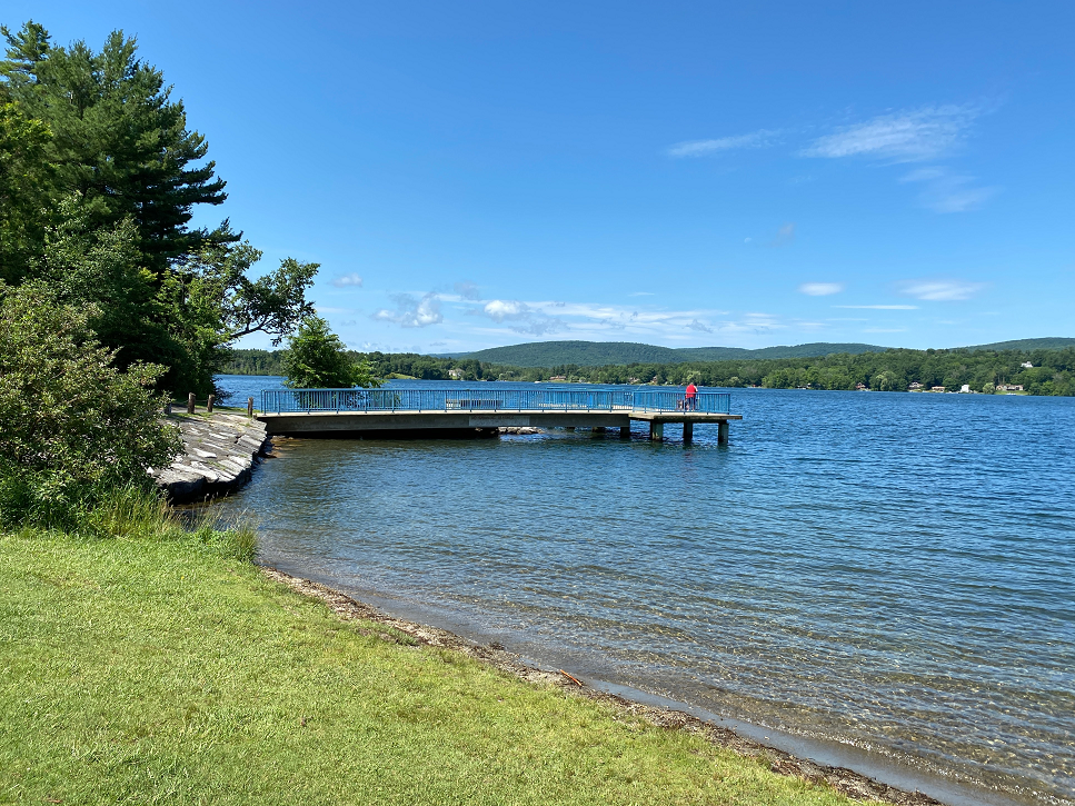 A man fishing from the pier at Onota Lake.